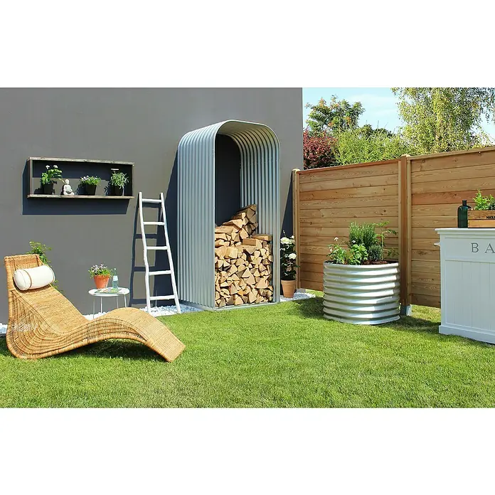 Vitavia Kaminholzregal Lignum 858 - 86 x 99 x 223 cm, Aluminium, Grau - Einladende Gartenszene mit stilvollem Holzregal, gemütlicher Liege und einer kreativen Holzlagerlösung.