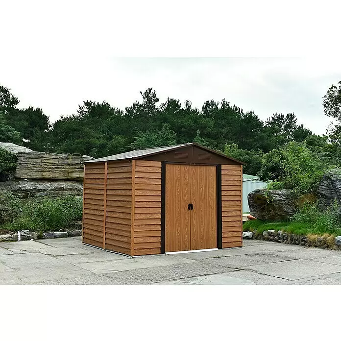 Pergart Gerätehaus Frankfurt II - 321 cm, 366 cm, Stahl, Braun, Grundfläche: 10,88 m² - Brauner Gartenschuppen in Holzoptik mit dunkelbraunem Metalldach und Doppeltüren auf einer gepflasterten Terrasse im Grünen.