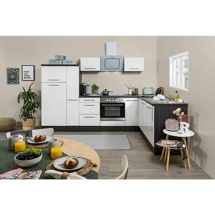 Respekta Premium Winkelküche RP290EWCBO - B x T: 290 x 200 cm, Weiß, Mit Elektrogeräten - Helle, moderne Küche mit weißen Schränken, dunklen Arbeitsplatten und einem runden Esstisch mit Frühstücksutensilien im Vordergrund.