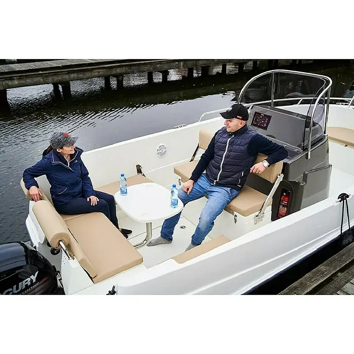 PEGAZUS GFK-Boot 605 CC Base - Ohne Motor, Geeignet für: 8 Personen, CE-Klasse C - Ein Boot mit bequemen Sitzen, einem Tisch und einer Steuerungseinheit mit Windschutzscheibe. Zwei Personen genießen die Fahrt.