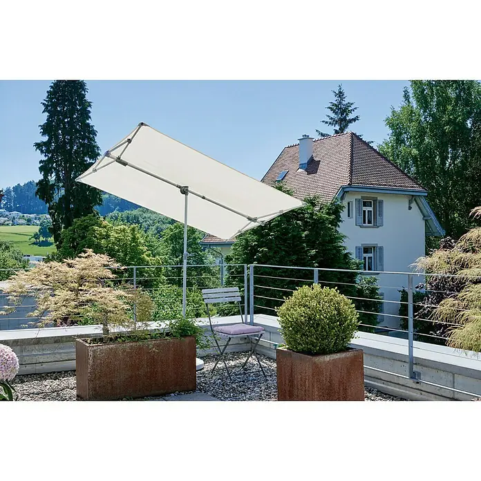 Suncomfort Balkonschirm Flex Roof - Ecru, Bespannungsmaß (L x B): 195 x 140 cm - Eine rechteckiger, cremefarbener Sonnenschirm steht auf einem Kiesterrasse, umgeben von Pflanzen und einer schlichten Metallbestuhlung.
