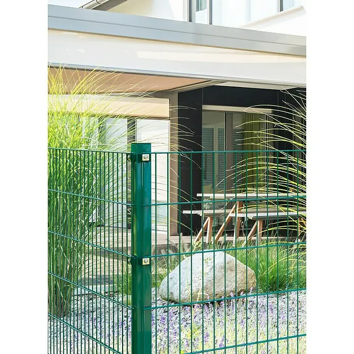 Eckpfosten - Höhe: 175 cm, Durchmesser: 60 mm, Grün, Metall - Nahaufnahme eines grünen Doppelstabmattenzauns, der einen Garten mit Steinen und Pflanzen umgibt und Privatsphäre schafft.