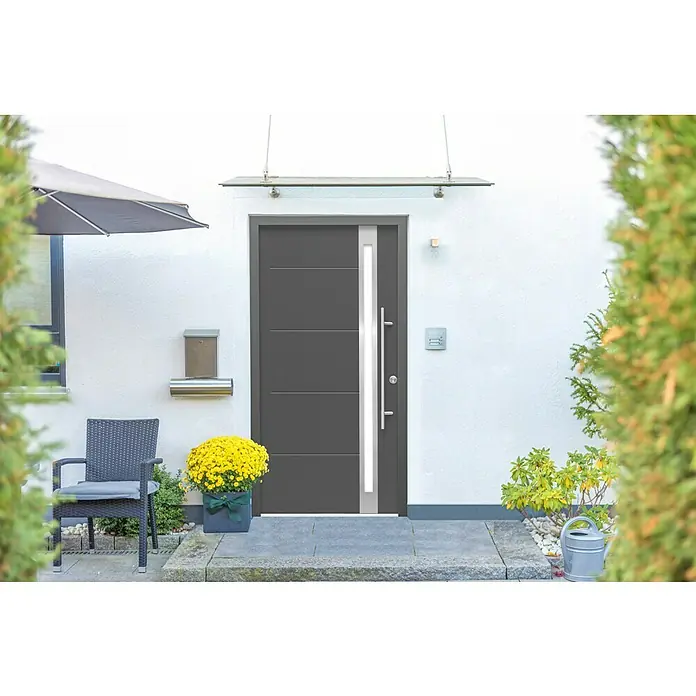 Splendoor Haustür Thermodoor PLUS SP30 - 100 x 210 cm, DIN Anschlag: Rechts, Anthrazitgrau Feinstruktur - Moderne Haustür in Anthrazit mit Glaselement und Überdachung vor einer hellen Hauswand, dekoriert mit Blumen und Gartenmöbeln.