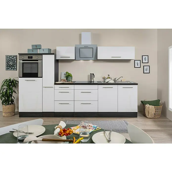 Respekta Premium Küchenzeile RP300HEWBO - Breite: 300 cm, Weiß, Mit Elektrogeräten - Helle Küche mit weißen Schränken, dunkler Arbeitsplatte und Esstisch im Vordergrund, die moderne Einrichtung und das stilvolle Ambiente hervorhebt.