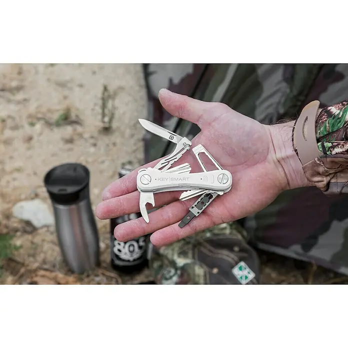 Nite Ize Llavero Key Smart Pro - Largo: 9,2 cm, Acero, 14 Llaves - Primer plano de un llavero KeySmart con múltiples herramientas en una mano, ideal para el transporte diario y actividades al aire libre.