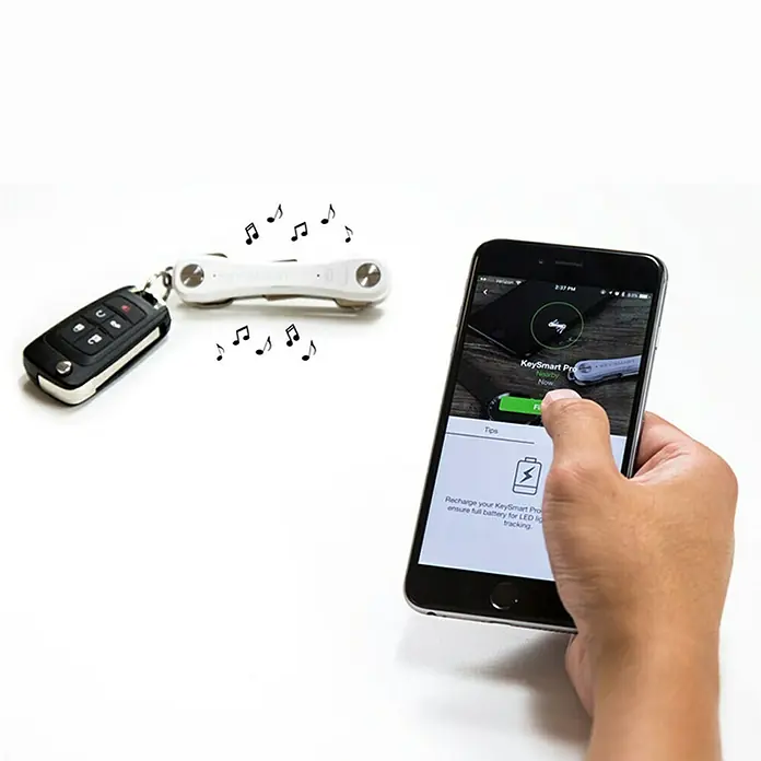 Nite Ize Llavero Key Smart Pro - Largo: 9,2 cm, Acero, 14 Llaves - Primer plano de un buscador de llaves KeySmart Pro con llavero y un teléfono inteligente que muestra la aplicación.