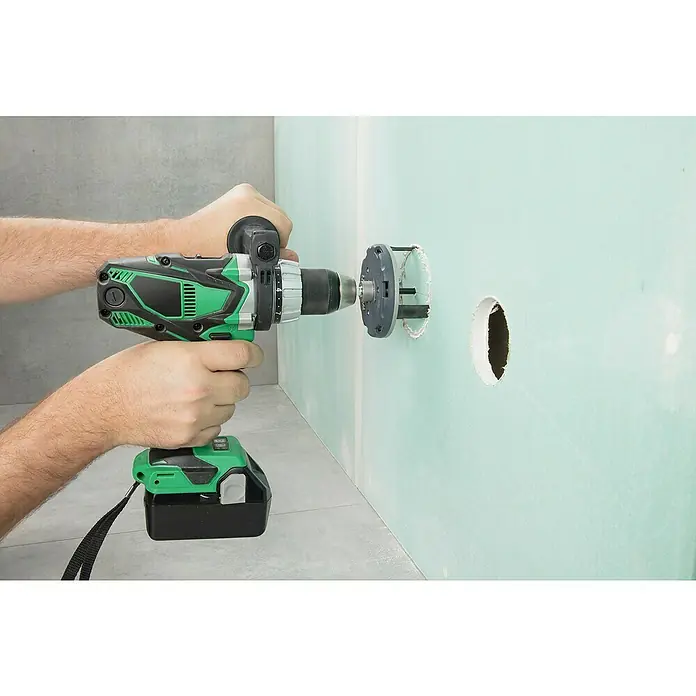 Wolfcraft Sierra de corona 5985000 - Diámetro: 35 mm - 80 mm - Un taladro verde con una sierra de corona está haciendo un agujero en una pared verde.