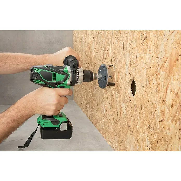 Wolfcraft Sierra de corona 5985000 - Diámetro: 35 mm - 80 mm - Un taladro inalámbrico verde se utiliza para perforar un agujero en una pared de madera, utilizando un accesorio de sierra de agujero que ya ha creado un agujero.