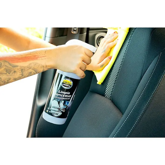 Limpiador para tapicería MOT50003 - 500 ml - Una persona limpia un asiento de coche con el limpiador de tapicería "GBC Car Cleaners Limpia Tapicerias" y un paño amarillo. Producto al centro.