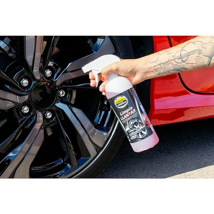Limpiador de llantas MOT50001 - 500 ml - Primer plano de un spray limpiador de ruedas de CDC Car Cleaners que se aplica a una rueda de coche negra brillante.