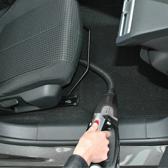 Aspirador de mano de batería Autovac - 50 W, Volumen de recipiente: 0,15 l - Se está utilizando una aspiradora de mano para limpiar el interior de un coche. La aspiradora es compacta y fácil de usar para el cuidado del automóvil.