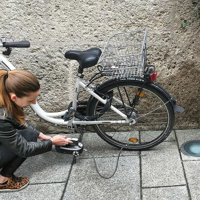 Aspirador de mano de batería Autovac - 50 W, Volumen de recipiente: 0,15 l - Mujer infla un neumático de bicicleta con una bomba de aire portátil, ideal para usar en ruta para una presión óptima.