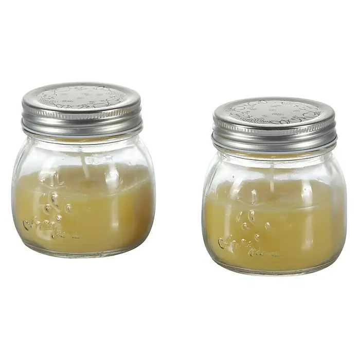 Duftkerze Citronella Potty im Glas - Ø x H: 8 x 9 cm - Zwei Glasbehälter mit silbernen Deckeln, gefüllt mit gelber Substanz, wahrscheinlich Kerzen, stehen auf einem schwarzen Hintergrund.