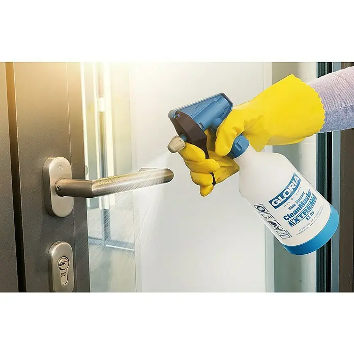 Gloria Feinsprüher Clean Master EXTREME EX 05 - Füllmenge: 0,5 l, Geeignet für: Desinfektionsmittel - Desinfektion mit dem Gloria CleanMaster EX 05: Eine Hand mit gelben Handschuhen sprüht Desinfektionsmittel auf einen Türgriff.