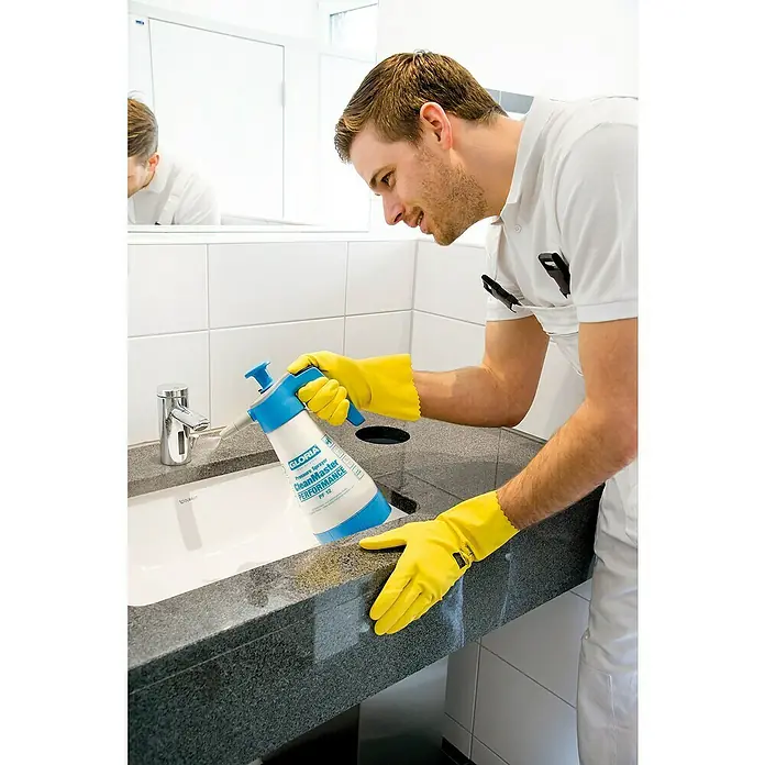 Gloria Drucksprühgerät Clean Master PERFORMANCE PF 12 - 1,25 l, Geeignet für: Desinfektionsmittel, Ölbeständig - Ein Mann reinigt ein Waschbecken mit einem Gloria CleanMaster Performance Drucksprüher, geschützt durch gelbe Handschuhe.