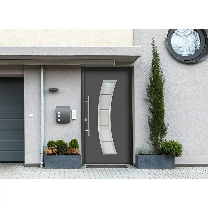 Splendoor Haustür Thermodoor PLUS SP10 - 110 x 210 cm, DIN Anschlag: Links, Anthrazitgrau Feinstruktur - Graue Haustür mit Glasdetails und langem Griff, eingebettet in eine moderne Fassade mit Pflanzenkästen und einem runden Fenster.