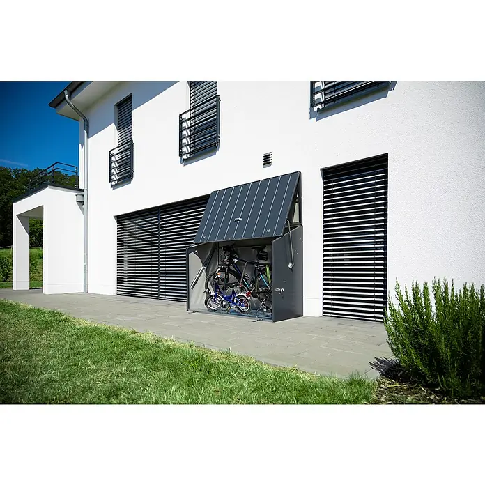 Trimetals Fahrradgarage - 185 x 76 x 139 cm, Stahl - Ein Fahrradunterstand in Grau mit Fahrrädern davor, neben einem weißen Haus mit Jalousien und Grünfläche.