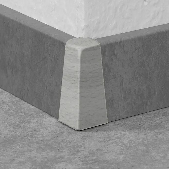 LOGOCLIC Außenecke K40 C - Buche Grau, 2 Stk., Passend für: LOGOCLIC Sockelleiste K40 C - Ein Detailaufnahme einer grauen Sockelleiste mit Eckstück, die einen sauberen Übergang zwischen Wand und Boden bildet.