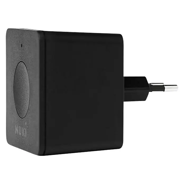 Nuki Módulo transmisor inalámbrico Bridge - Específico para: Cerradura electrónica Nuki, Negro - Primer plano de un enchufe Nuki negro, diseñado para cargar dispositivos, presentado sobre un fondo oscuro.