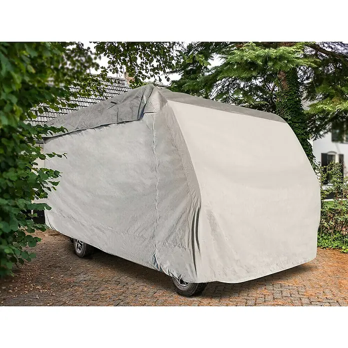 Wohnmobil-Abdeckplane - L x B x H: 750 x 235 x 270 cm, Grau - Eine Wohnwagenabdeckung schützt das Fahrzeug vor Witterungseinflüssen und Schmutz. Sie ist grau und bedeckt den gesamten Wohnwagen auf einem Steinpflaster.