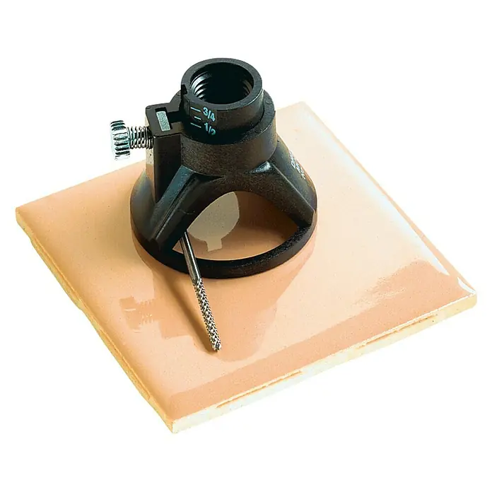 Dremel Fräsvorsatz Mod. 566 - Geeignet für: Keramikfliesen, Arbeitstiefe: 19 mm - Nahaufnahme einer Fliesenbohrkrone auf einer beigen Fliese, ideal zum präzisen Bohren von Löchern in Fliesen.
