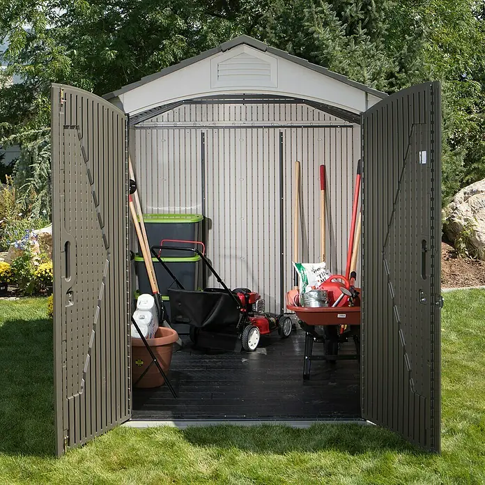 Gerätehaus Phoenix - Außenbreite inkl. Dachüberstand: 206 cm, Außentiefe inkl. Dachüberstand: 280 cm, Kunststoff, Lichtgrau/Anthrazit - Gartenhaus mit geöffneten Türen, gefüllt mit Gartengeräten wie Rasenmäher und Schubkarre. Ideal zur Aufbewahrung von Gartenzubehör.