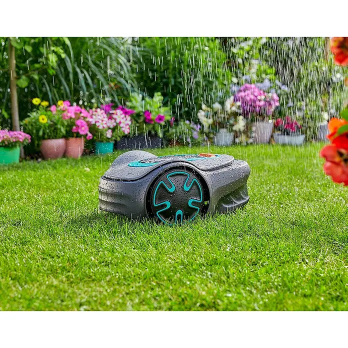 Gardena Robot cortacésped Sileno Minimo 250 - 2,1 Ah, Recomendación máxima de superficie: 250 m² - Un robot cortacésped Gardena está sentado en la hierba verde bajo la lluvia. Flores coloridas florecen al fondo.