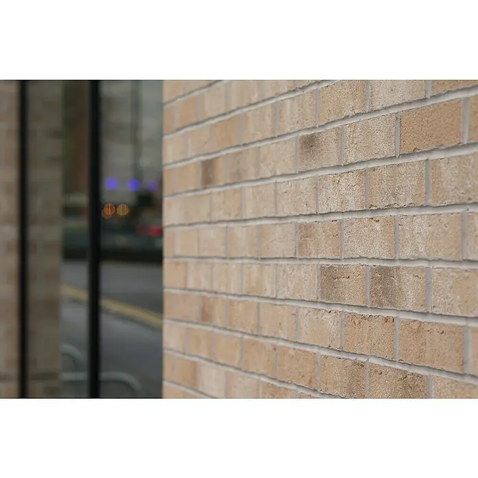 Celina Klinker Verblendstein Handstrich Valencia - 21,5 x 6,5 cm, Beige, Steinoptik - Nahaufnahme einer sandfarbenen Backsteinmauer, die die Textur und das Muster der Ziegel zeigt, ein Bauelement für Aussenbereiche.