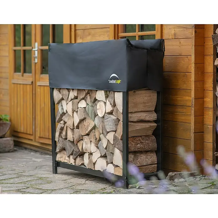 ShelterLogic Kaminholzregal - 119,4 x 36,3 x 119 cm, Stahl, Schwarz - Nahaufnahme eines ShelterLogic Holzregals mit einer schwarzen Abdeckung, das mit Holzscheiten gefüllt ist und vor einem Holzhaus steht.