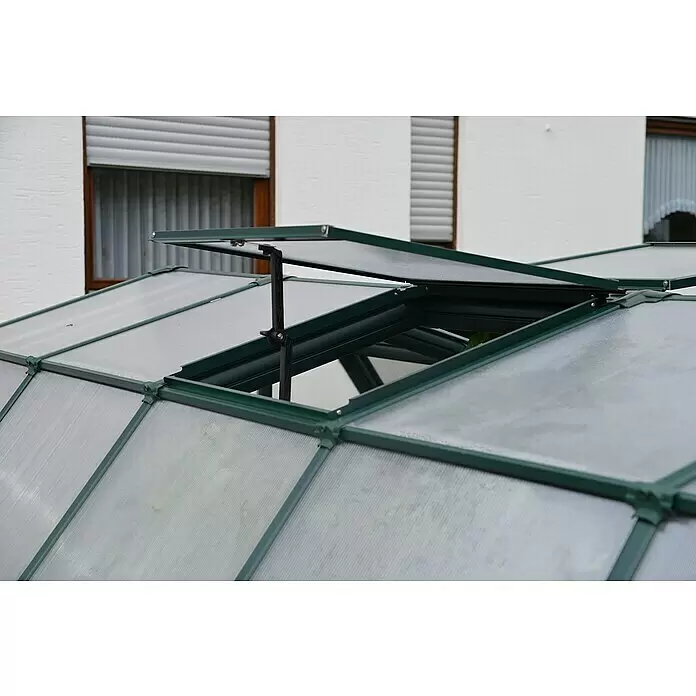Palram – Canopia Ventana de techo para invernadero - Verde - Techo de invernadero verde oscuro con ventilación translúcida abierta para aireación, frente a un edificio.