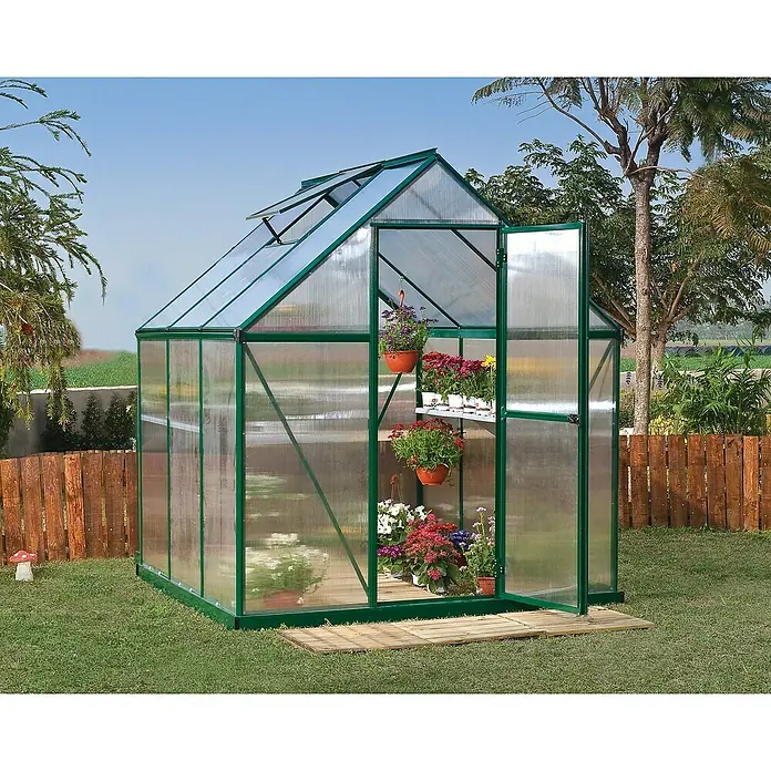 Palram – Canopia Invernadero Mythos - Medidas ext. (An x Pr): 185 x 186 cm, 4 mm, Verde - Un invernadero verde con una puerta abierta está en el jardín, lleno de flores coloridas. El invernadero ofrece suficiente espacio.
