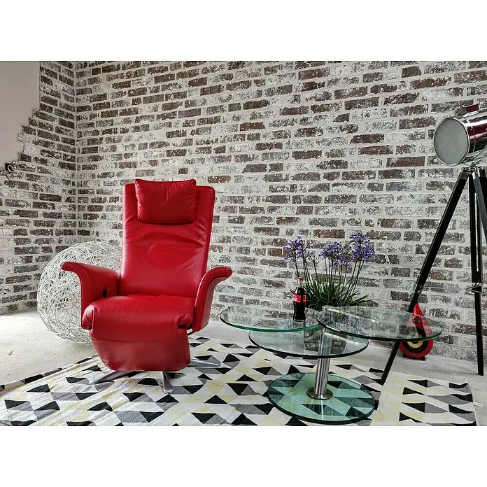 Celina Klinker Verblendstein Vintage Sydney - 7,1 x 24 cm, Weiß/Braun, Steinoptik - Ein roter Ledersessel steht auf einem geometrischen Teppich, neben einem Couchtisch mit Blumen und einer Stehlampe.