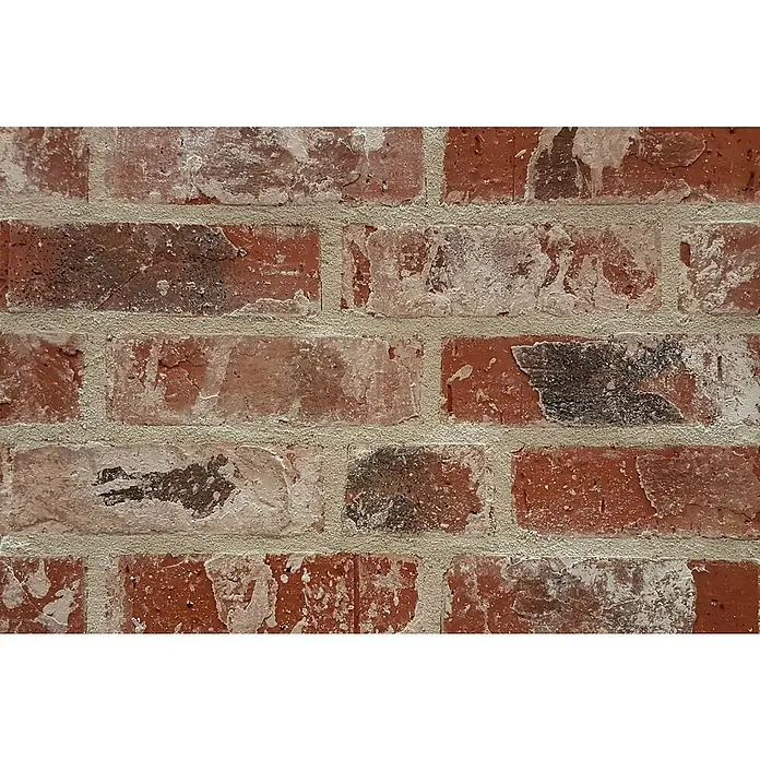 Celina Klinker Verblendstein Vintage New York - 7,1 x 24 cm, Braun/Rot, Steinoptik - Nahaufnahme einer detailreichen Backsteinmauer mit auffälligen roten Farbtönen und verwitterten, weißen Akzenten. Die Textur der Mauer ist rau und rustikal.