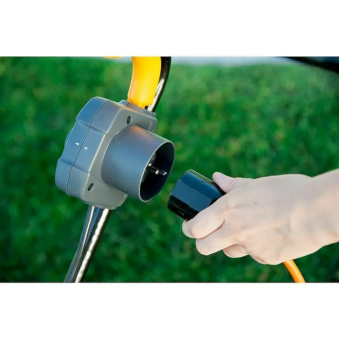 Stiga Elektro-Vertikutierer SV 213 E - 1.300 W, Arbeitsbreite: 32 cm - Nahaufnahme eines Rasenmähers, der an das Stromnetz angeschlossen wird. Der Stecker wird in die Steckdose des Geräts gesteckt.
