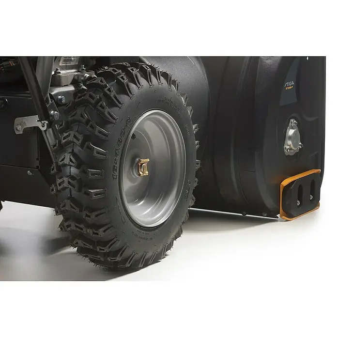 Stiga Benzin-Schneefräse ST 5266 P - 6,2 kW, 302 cm³, Arbeitsbreite: 66 cm - Nahaufnahme eines Stiga Schneefräsenrads mit grobem Profil und silberner Felge, ideal für Winterbedingungen.