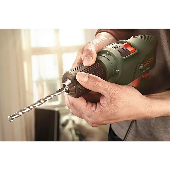 Bosch Schlagbohrmaschine EasyImpact 600 - 600 W, Leerlaufdrehzahl 1. Gang: 45.000 U/min - Nahaufnahme eines Bosch EasyImpact 600 Bohrers mit eingesetztem Bohrer, gehalten von einer Person.