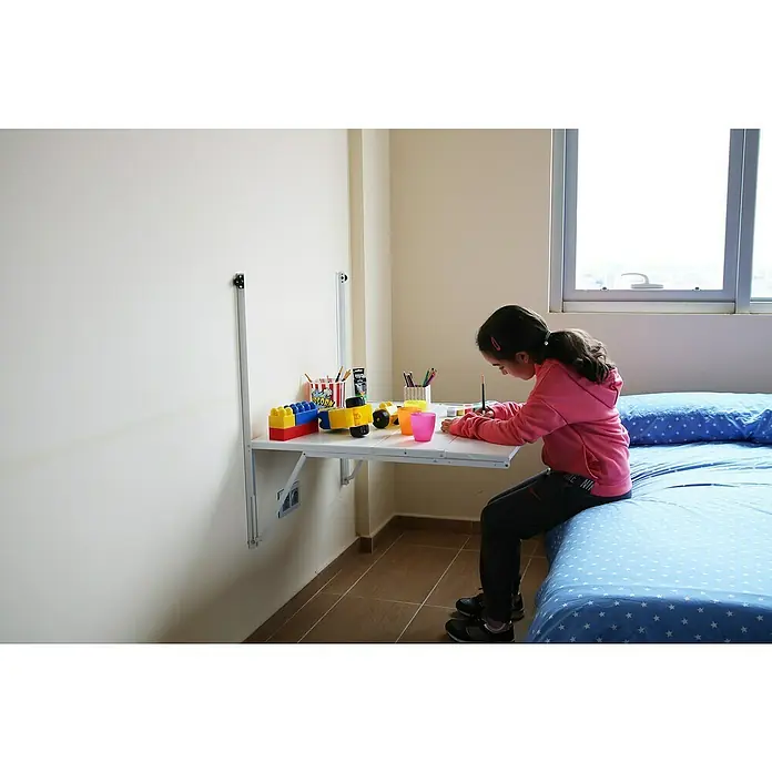 Simonrack Simonflex Estantería metálica - Al x An x Pr: 112,5 x 80 x 40 cm, Blanco - Niña pintando en una mesa plegable. La mesa plegable está llena de juguetes y materiales de arte mientras la niña crea arte.