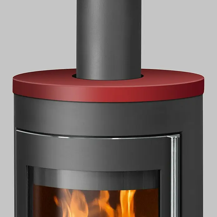 Justus Kaminofen Meva - 5,5 kW, Raumheizvermögen: 88 m³, Farbe Verkleidung: Bordeauxrot, Schwarz - Nahaufnahme eines schwarzen Kaminofens mit roter Oberseite und sichtbarem Feuer hinter einer Glasscheibe.