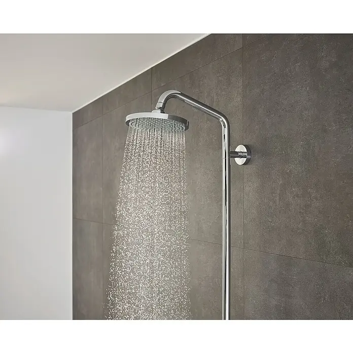 Hansgrohe Duschsystem Croma Showerpipe 160 - Mit Thermostatarmatur, Lochabstand: 93,2 cm, Anzahl Strahlarten: 4 Stk., Chrom, Höhe: 110,1 cm - Naheaufnahme eines modernen Chrom-Duschkopfes, der Wasserstrahlen abgibt, vor einer grauen gefliesten Wand.