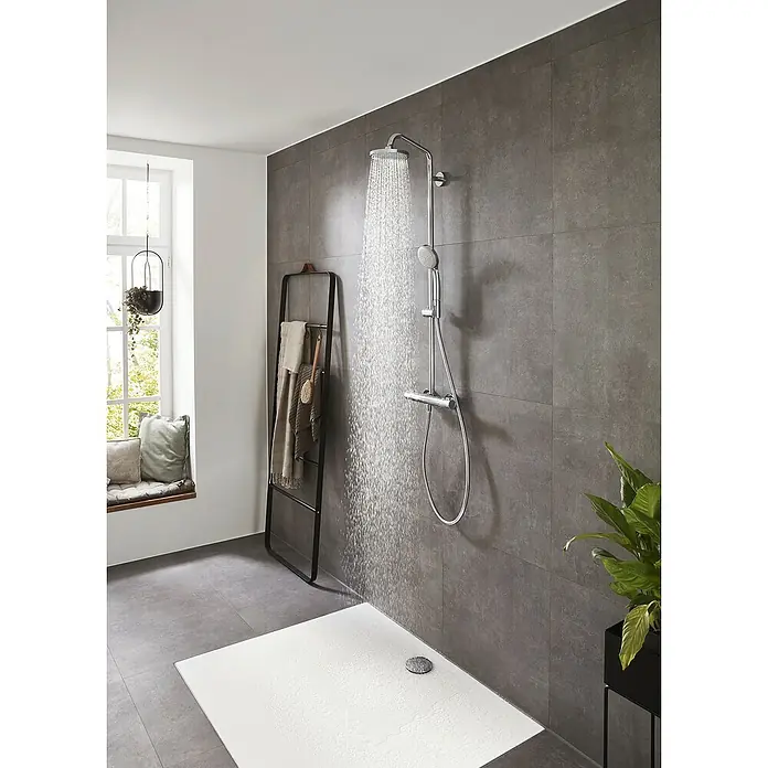 Hansgrohe Duschsystem Croma Showerpipe 160 - Mit Thermostatarmatur, Lochabstand: 93,2 cm, Anzahl Strahlarten: 4 Stk., Chrom, Höhe: 110,1 cm - Dusche mit grau gefliester Wand und Regendusche mit Handbrause sowie Handtuchhalter.