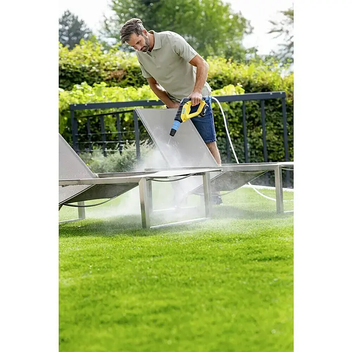 Gloria Power for All 18V Limpiadora a presión Gloria - 18 V, Iones de litio, Sin batería, Presión máx.: 24,9 bar - Un hombre limpia una tumbona de jardín con una hidrolimpiadora amarilla en el jardín.