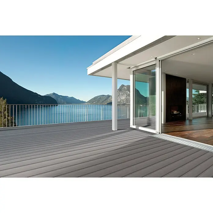 Kovalex Entwässerungsprofil - 100 x 15 x 2,6 cm, Passend für: Kovalex WPC-Terrassendielen Stärke 2,6 cm - Großes modernes Haus mit einer grauen Verbundholzterrasse und einem atemberaubenden Blick auf den See für Entspannung im Freien.