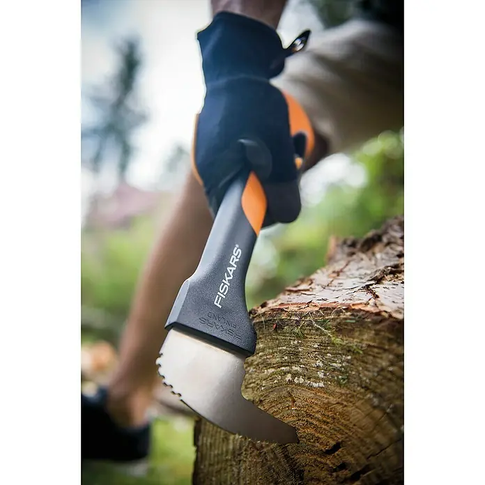 Fiskars WoodXpert Sappie XA2 - 35 cm - Nahaufnahme einer Fiskars Axt mit einer Hand, die sie in ein Stück Holz hackt. Ein hochwertiges Werkzeug für jeden Holzarbeiter.