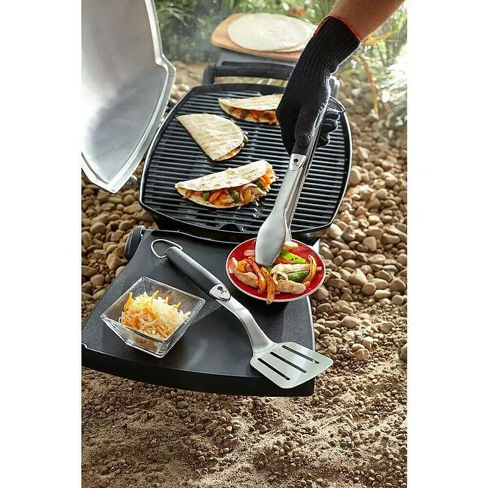 Weber Utensilios para barbacoa Compacto - 2 pzs., Acero inoxidable - Primer plano de una parrilla con quesadillas, pinzas, espátula y queso. Ideal para deliciosas comidas al aire libre.