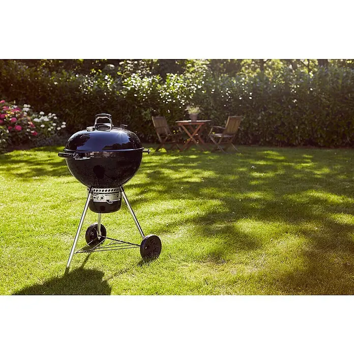 Weber Master-Touch GBS Kugelgrill E-5750 - Durchmesser Grillfläche: 57 cm, Schwarz - Ein klassischer Kugelgrill in Schwarz steht auf einem grünen Rasen, ideal für sommerliche Grillabende im Garten.