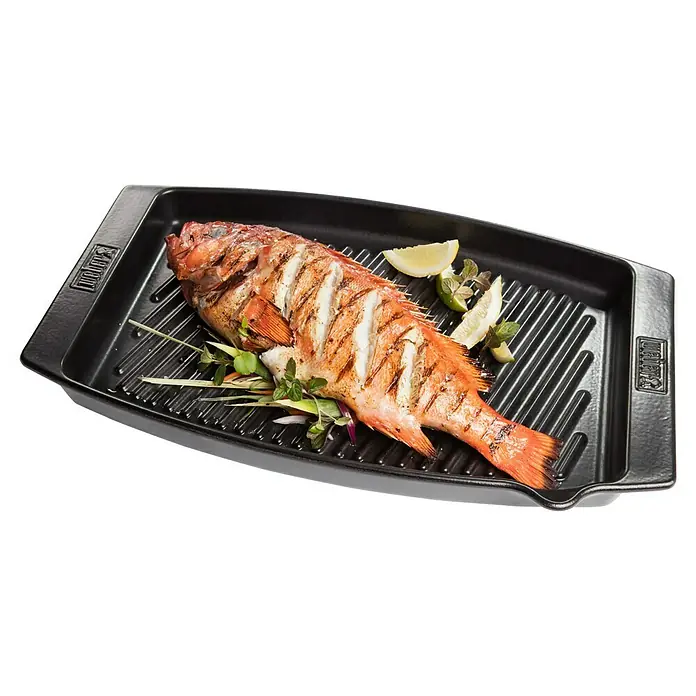 Weber Grillpfanne BBQ Keramik - L x B: 47 x 28 cm, Höhe: 4,4 cm - Gegrillter Fisch mit Zitronenspalten auf einer schwarzen Grillplatte. Die Grillspuren sind auf dem Fisch deutlich zu erkennen.
