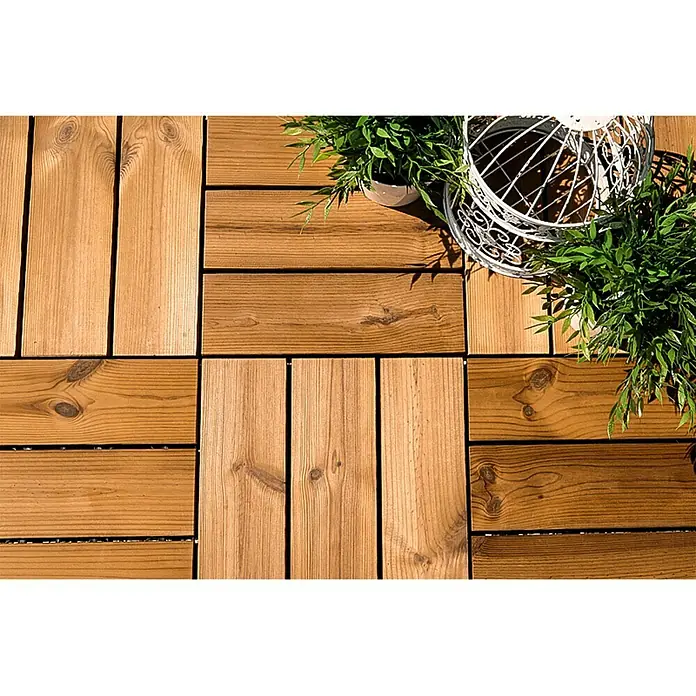 Loseta con sistema click Smartdeck - Pino, 30 x 30 x 2,5 cm, Natural, 6 ud. - La imagen muestra baldosas cuadradas de madera en tonos marrones cálidos, dispuestas en un patrón, complementadas con plantas y una jaula decorativa.