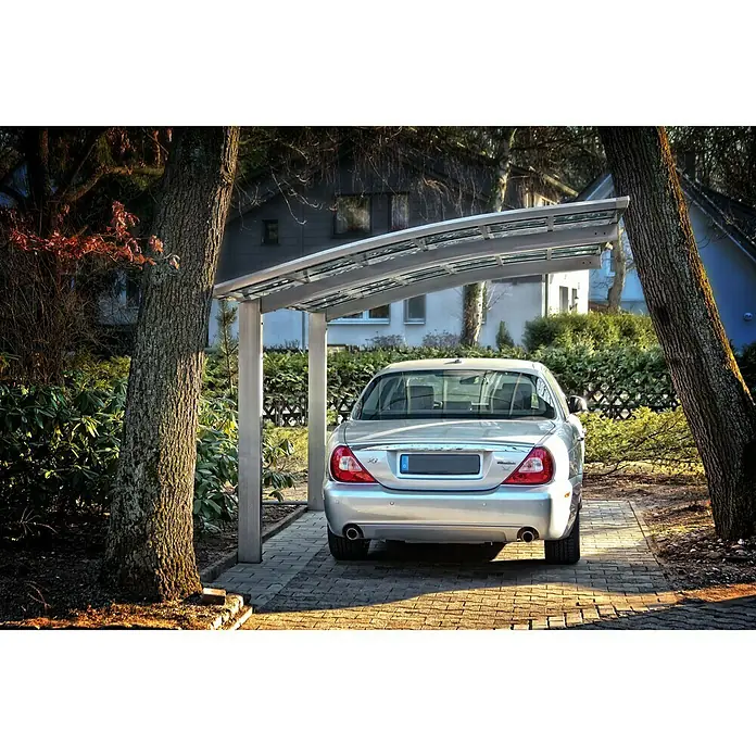 Ximax Carport Portoforte 110 - Außenmaß inkl. Dachüberstand (B x T): 2,7 x 4,95 m, Einzelcarport, Edelstahloptik, Schneelast: 137 kg/m² - Silberne Jaguar Limousine unter einem Carport zwischen Bäumen, gepflasterte Auffahrt.