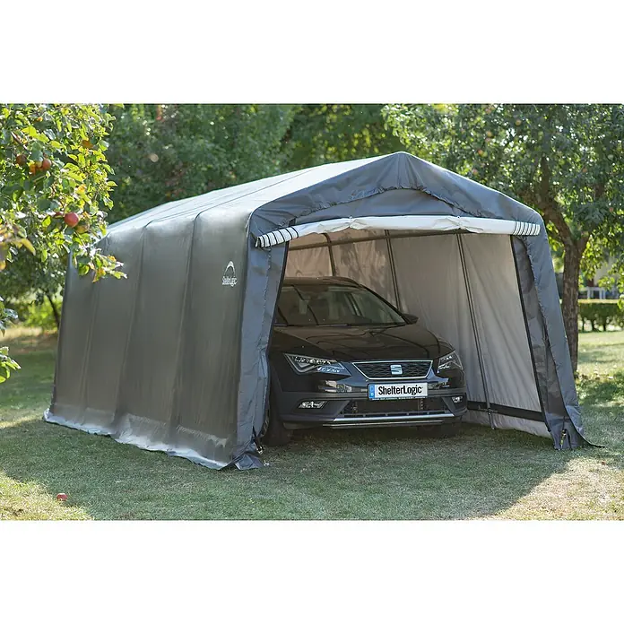 ShelterLogic Garage - 610 x 300 x 240 cm, Kunststoff - Ein ShelterLogic-Autounterstand aus grauem Stoff mit einem darin geparkten schwarzen Auto auf einer grünen Wiese.