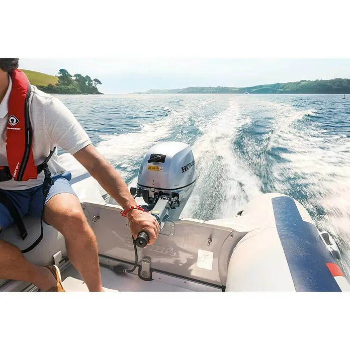 Honda Marine Außenbordmotor BF 15 SHU - 11 kW, Pinnensteuerung, Kurzschaft, Seilzug - Nahaufnahme eines Honda-Bootsmotors in Aktion, montiert an einem Schlauchboot auf dem Wasser.